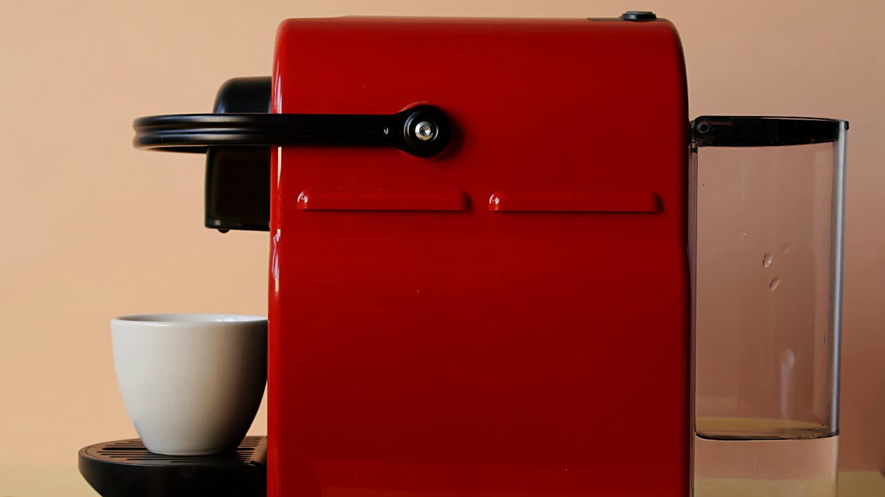 Red coffee machine with a white ceramic mug, ideal for coffee lovers and modern kitchens.