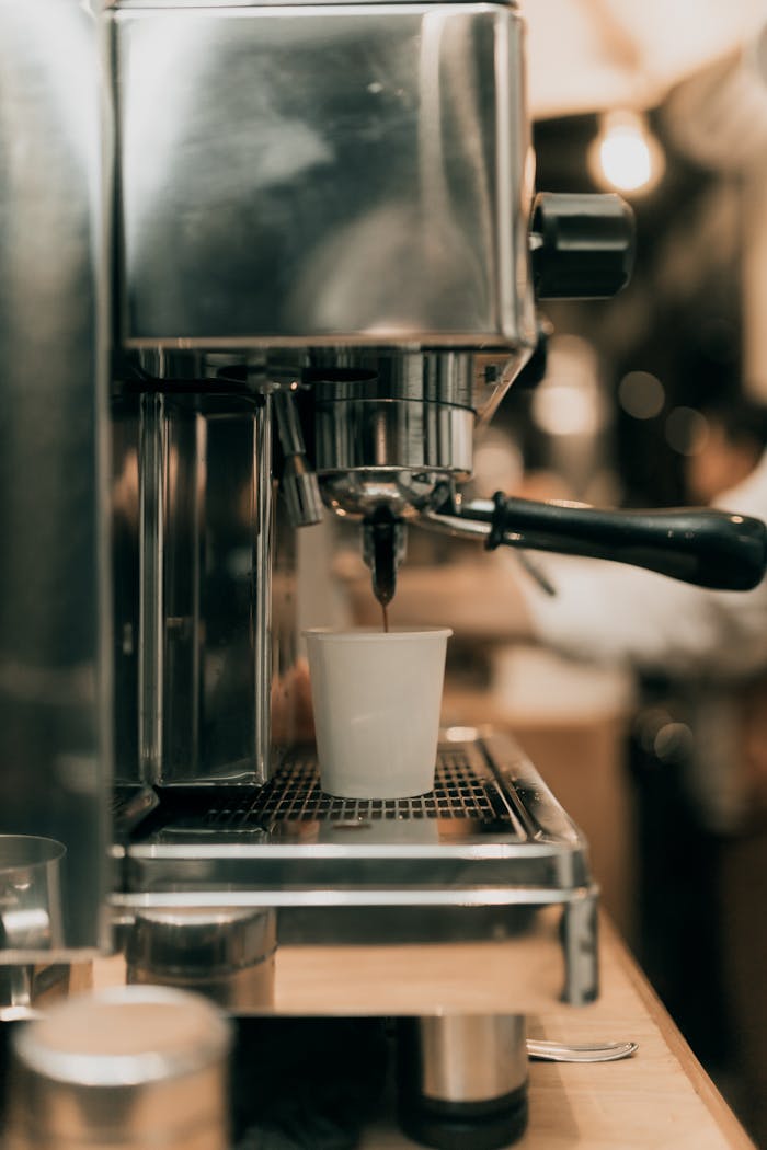 Close-up of espresso machine brewing hot coffee into a cup in a cozy cafe ambiance.