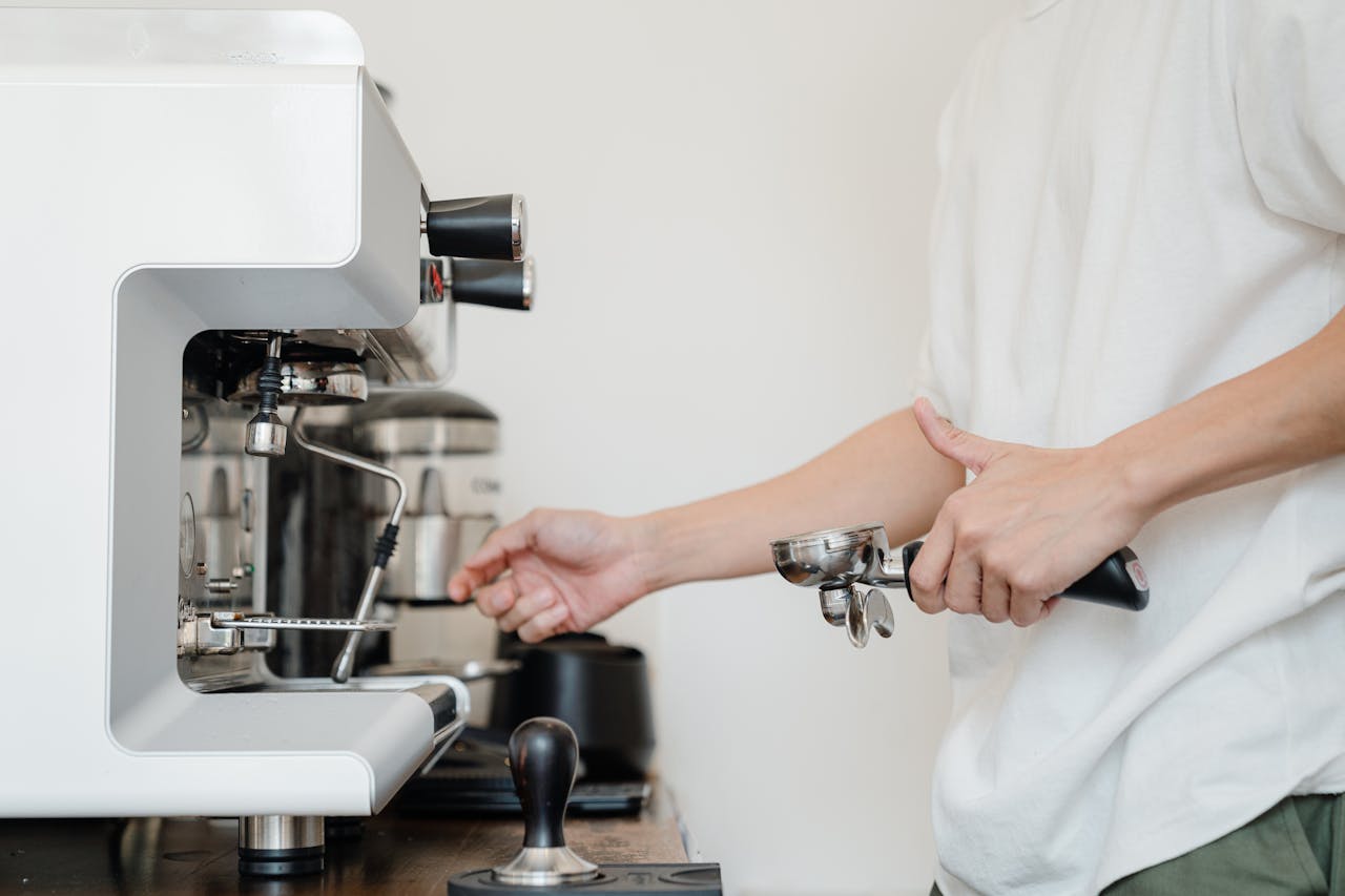 Close-up of a barista using an espresso machine indoors. Perfect for coffee-related content.