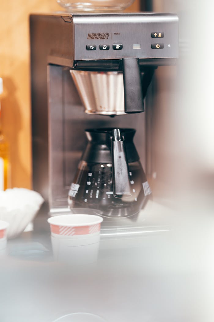 Close-up of a modern coffee machine brewing fresh coffee indoors.